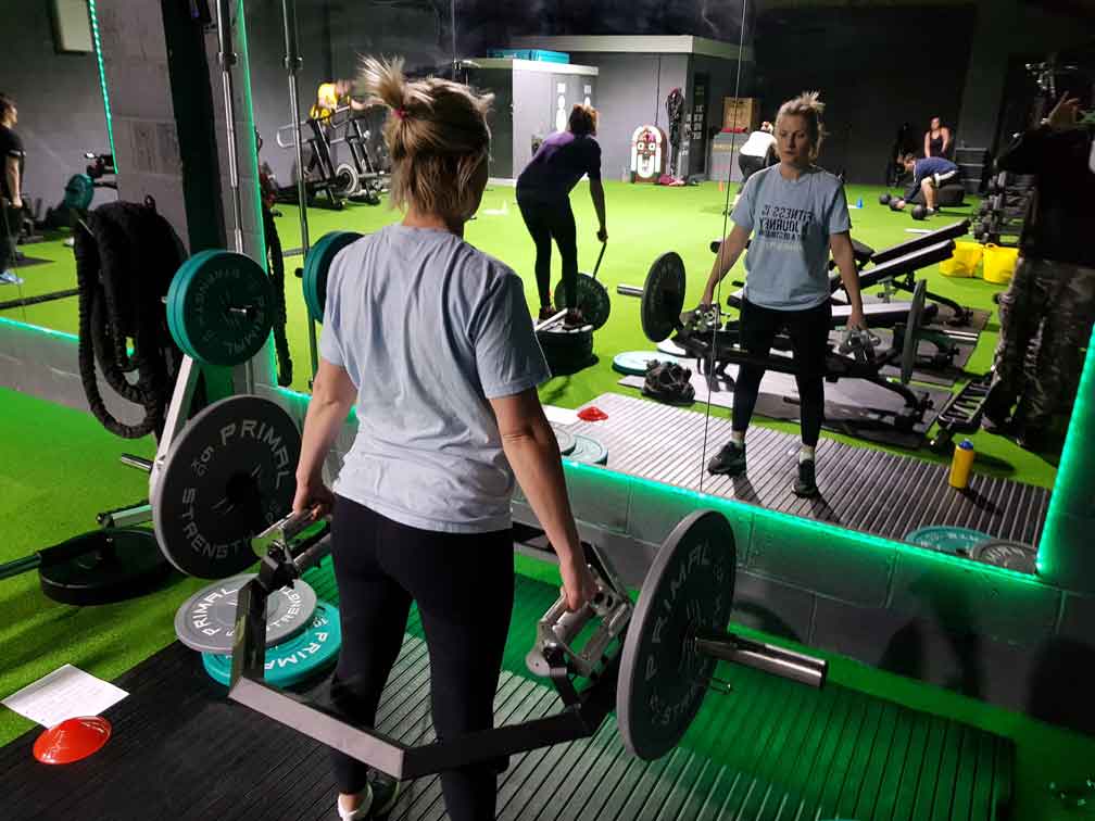 Sniper recruit lifting weights in front of a mirror